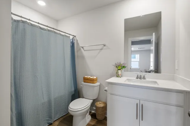 a bathroom with a sink a toilet and shower