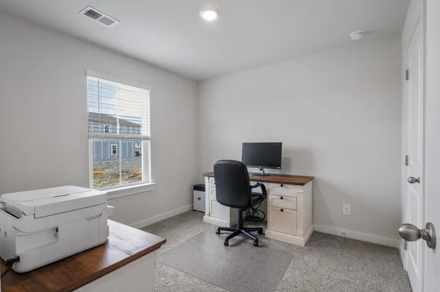 a view of a workspace with furniture and a window