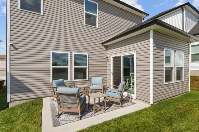 a view of a house with chairs and table in a patio