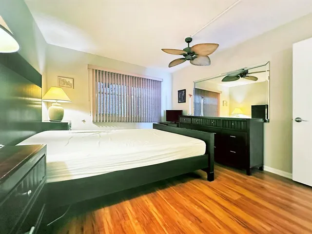 a spacious bedroom with a bed and a dresser