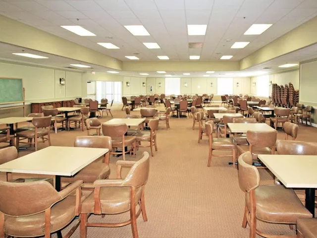 a view of a patio with table and chairs under an umbrella with a garden