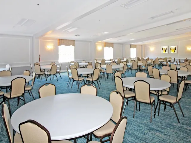 a front view of a multi story residential apartment building with yard and outdoor seating