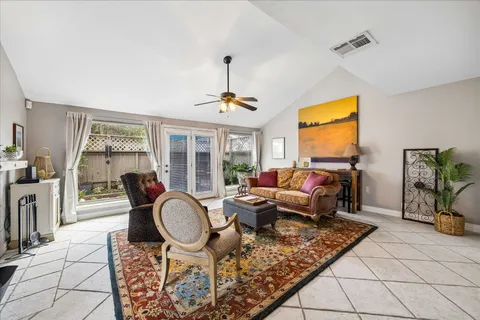 a living room with furniture a table and large windows