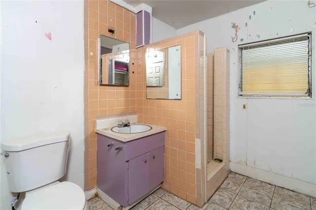 a bathroom with a granite countertop toilet a sink and a mirror