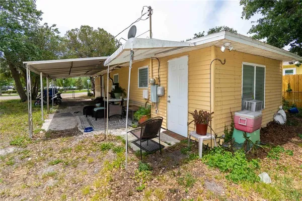 a backyard of a house with yard table and chairs