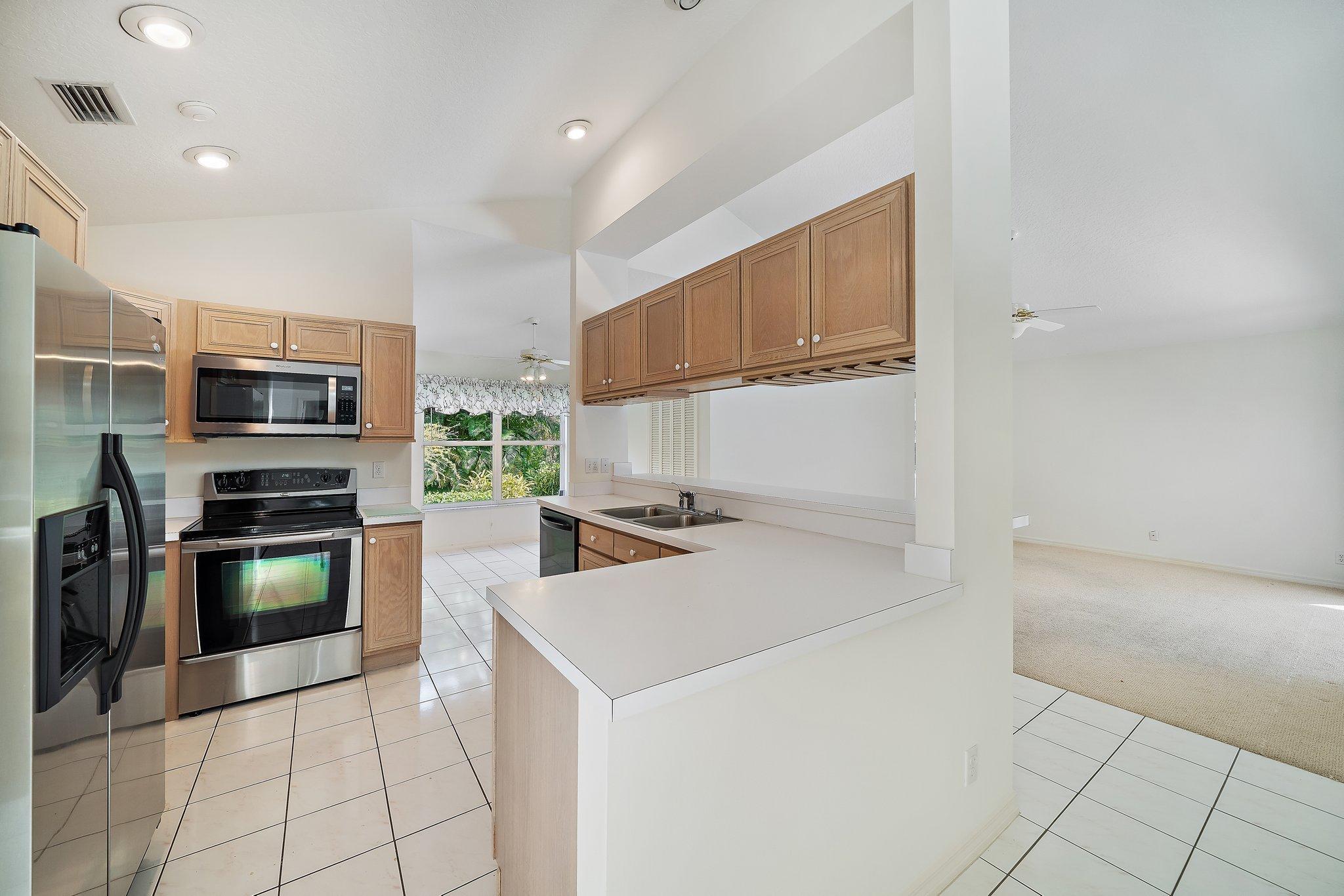 10424 Sandy Run Road Jupiter, FL 33478 - Photo 15 of 52 a kitchen with a sink a microwave and refrigerator