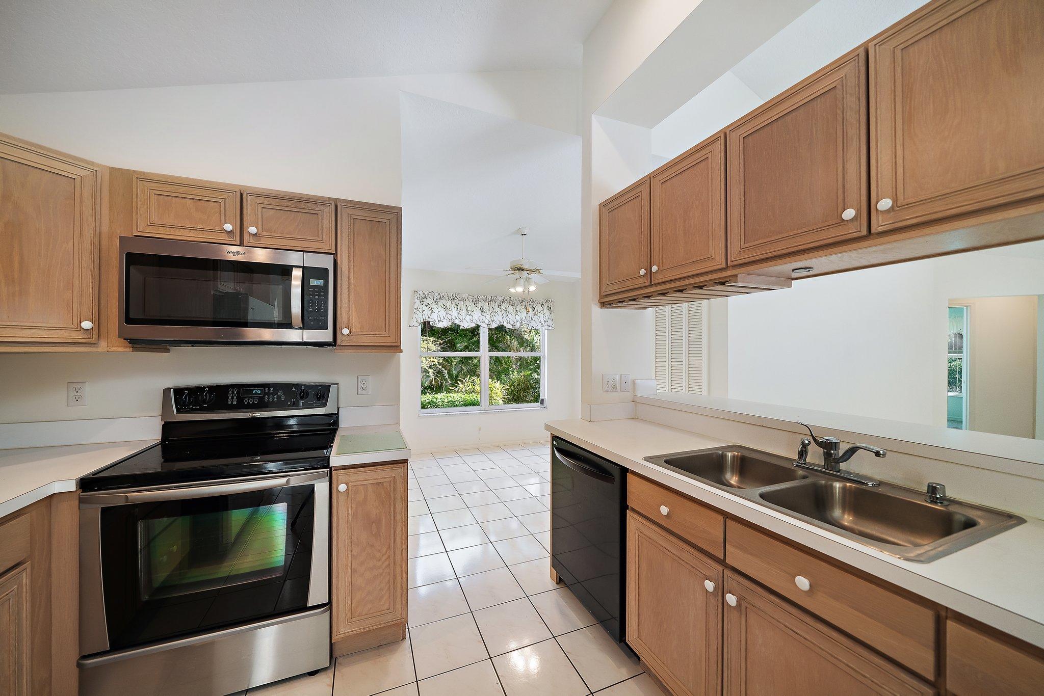 10424 Sandy Run Road Jupiter, FL 33478 - Photo 16 of 52 a kitchen with a sink stove and microwave