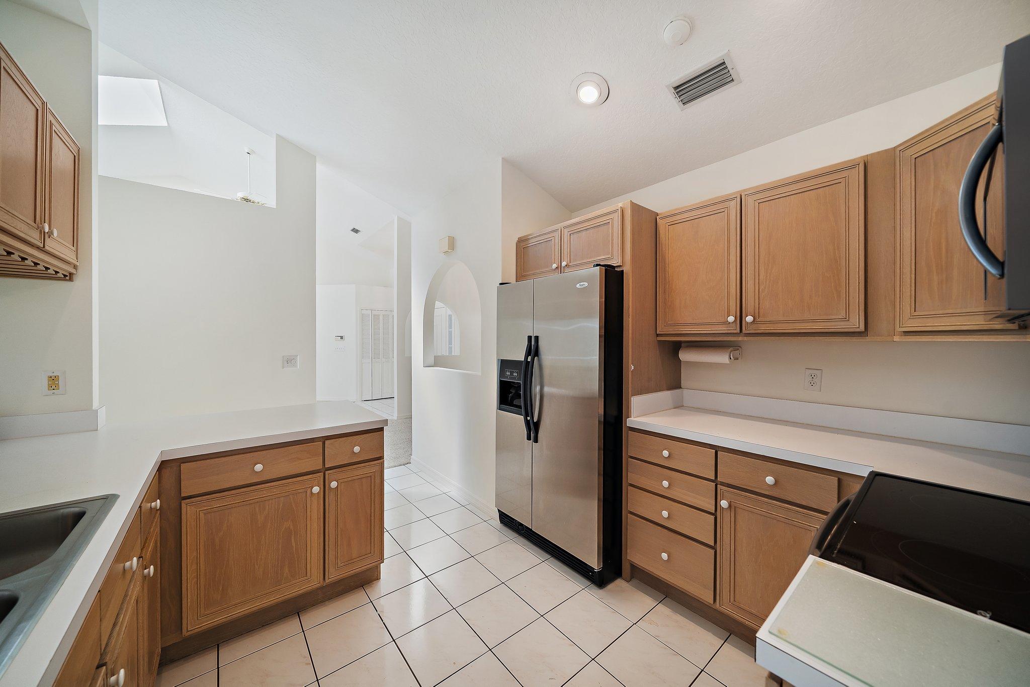 10424 Sandy Run Road Jupiter, FL 33478 - Photo 17 of 52 a kitchen with stainless steel appliances a refrigerator and cabinets