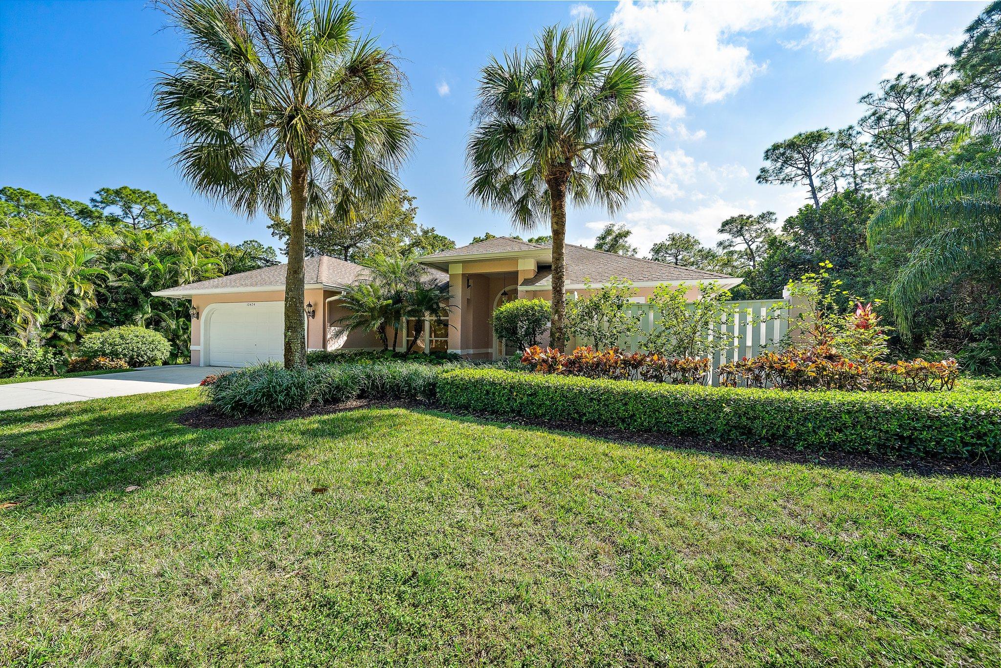 10424 Sandy Run Road Jupiter, FL 33478 - Photo 3 of 52 a front view of a house with garden and trees