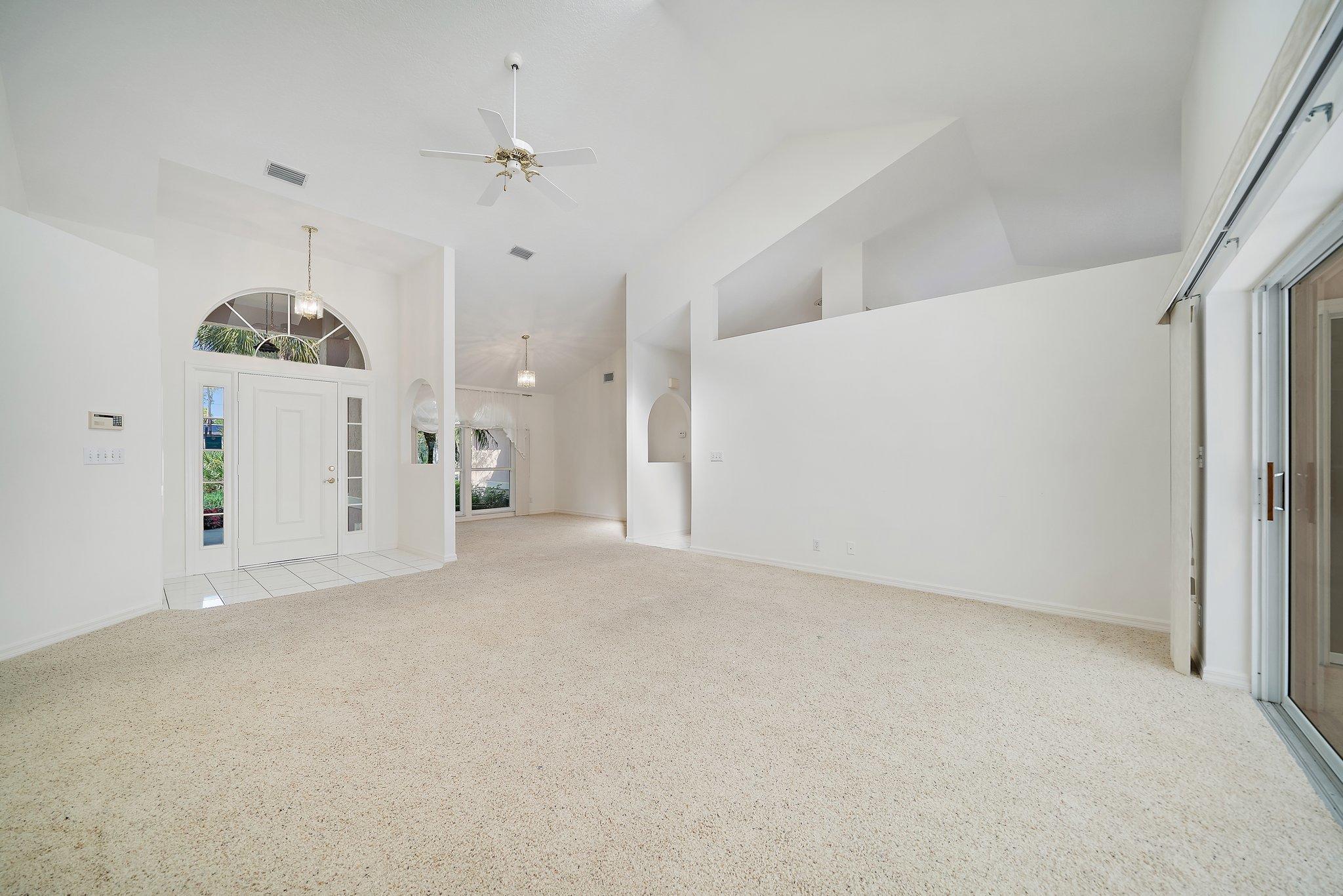 10424 Sandy Run Road Jupiter, FL 33478 - Photo 9 of 52 en empty room with an entryway and a chandelier