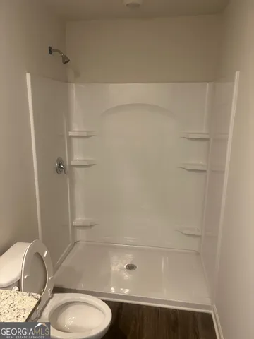 a bathroom with a toilet and a shower