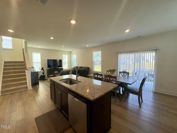 a dining hall with stainless steel appliances granite countertop a stove and a dining table