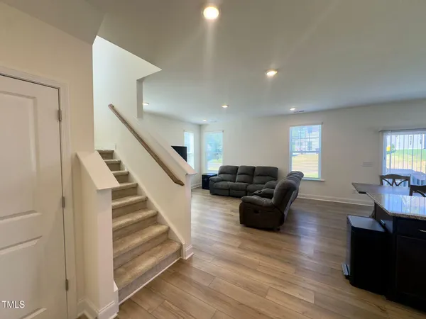 a living room with furniture and a wooden floor
