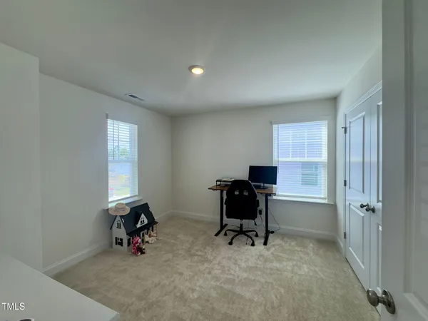 a view of a workspace with furniture and a window