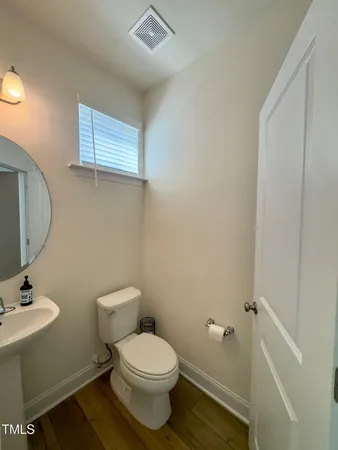 a bathroom with a toilet a sink and mirror
