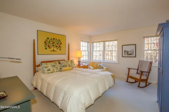 a bedroom with a bed a table and chair next to a window