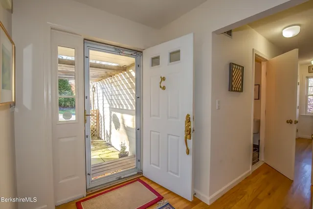 a view of a hallway with wooden floor and windows