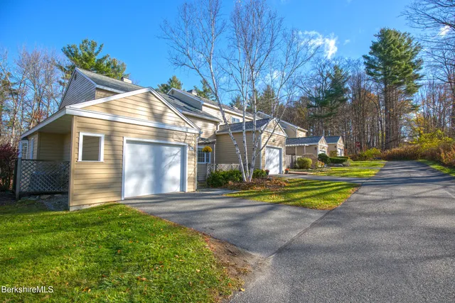 a front view of a house with a yard and fountain
