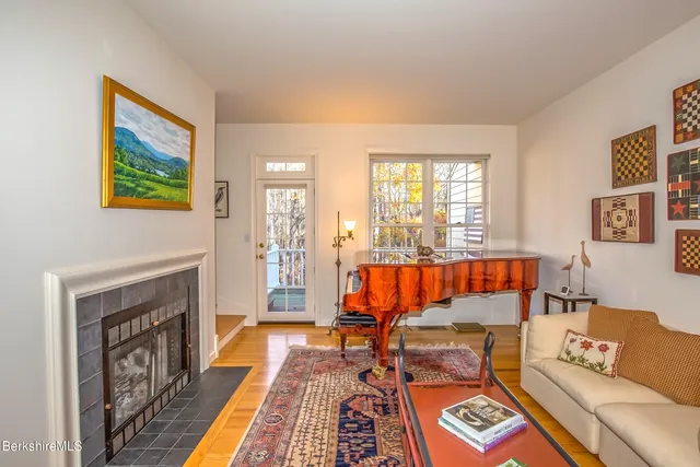 a living room with fireplace furniture and a rug