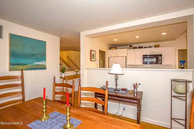 a living room with furniture a flat screen tv and kitchen view