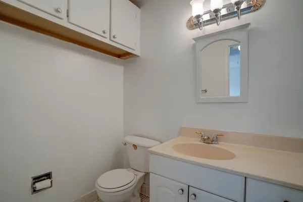 a bathroom with a toilet sink vanity and mirror