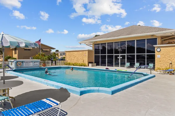 a view of a backyard with a swimming pool and sitting area