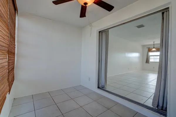 an empty room with fan and windows