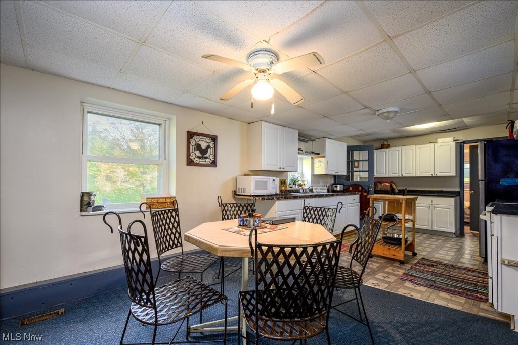 2641 Tower Road Jefferson, OH 44047 - Photo 11 of 35 Tiled dining space with ceiling fan and a drop ceiling