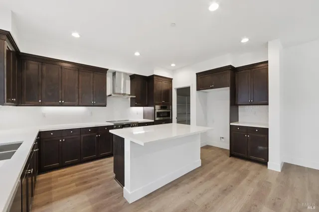 a kitchen with stainless steel appliances kitchen island granite countertop a refrigerator stove and sink