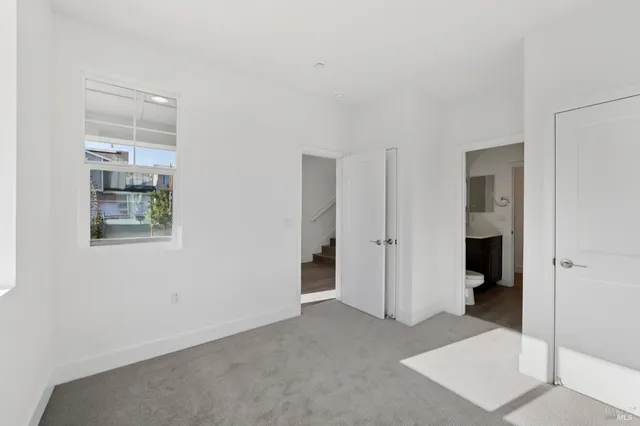 a view of an empty room with closet and a window