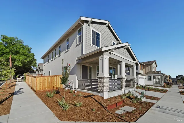 a view of a house with a small yard and wooden fence