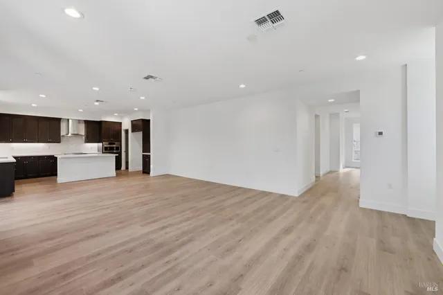 a view of kitchen with kitchen island a sink dishwasher and a stove with wooden floor