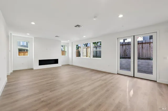 a view of an empty room with glass door and windows