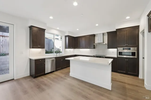 a large kitchen with stainless steel appliances kitchen island granite countertop a stove a sink a refrigerator and a microwave