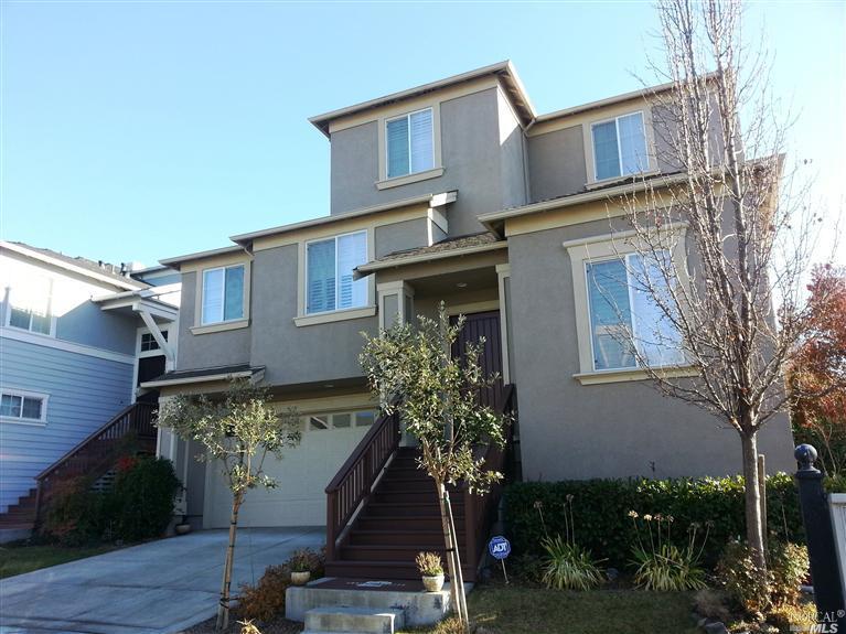 a front view of a house with a tree