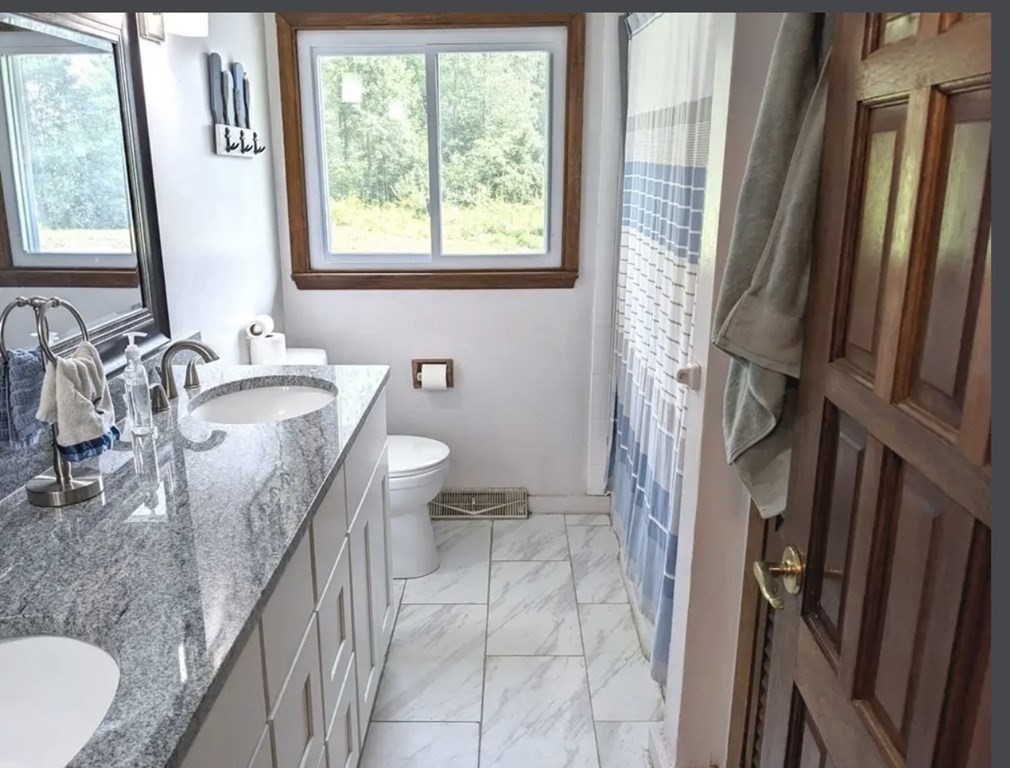 147 Forest Street Middleton, MA 01949 - Photo 13 of 32 a bathroom with a granite countertop sink and a mirror