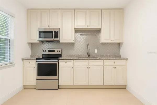 a kitchen with stainless steel appliances granite countertop white cabinets a sink and dishwasher