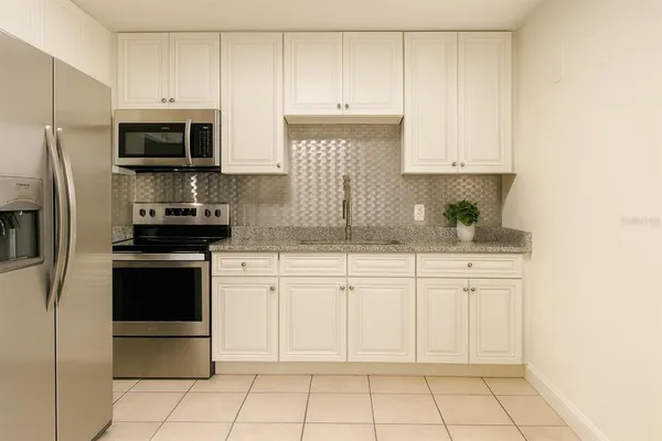 a kitchen with stainless steel appliances granite countertop a sink and a stove