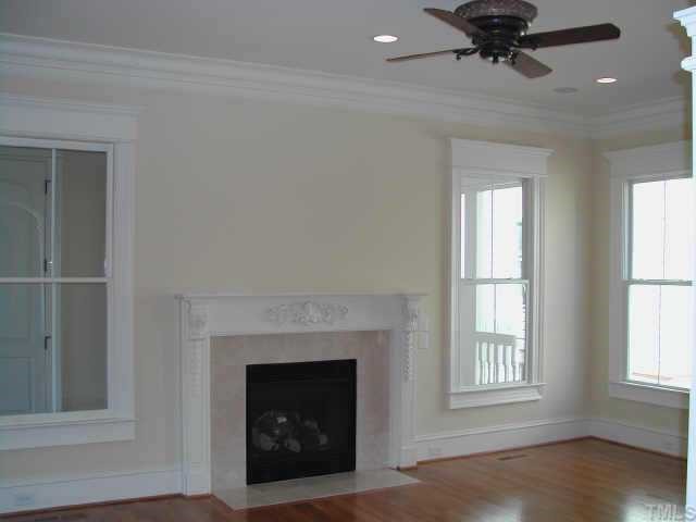 7830 Monument Lane Raleigh, NC 27615 - Photo 2 of 10 Family Room features Ceiling fan and Handcarved mantel