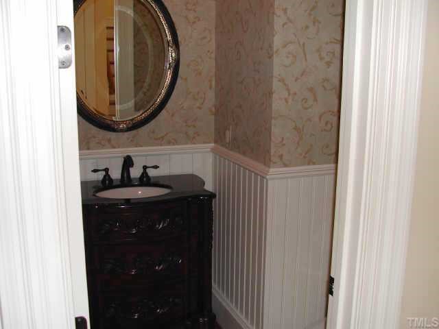 7830 Monument Lane Raleigh, NC 27615 - Photo 3 of 10 Powder Room features Beaded Wainscoting, Furniture Vanity and Wallpaper