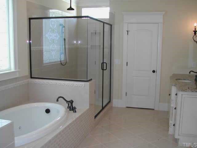 7830 Monument Lane Raleigh, NC 27615 - Photo 6 of 10 Master Bath features Light and Bright space with Luxurious Soaking Tub, Large Shower with Rain Shower Head and Hand-Held Shower Wand and granite countertops