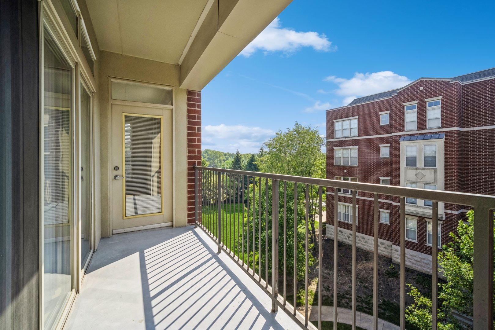 715 Astor Lane, Unit 402 Wheeling, IL 60090 - Photo 11 of 12 a view of a balcony with a floor to ceiling window and wooden floor