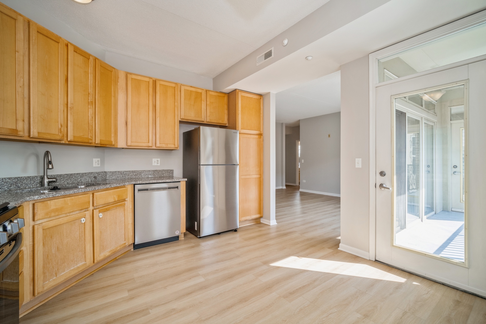 715 Astor Lane, Unit 402 Wheeling, IL 60090 - Photo 5 of 12 a kitchen with stainless steel appliances granite countertop a refrigerator and a stove top oven