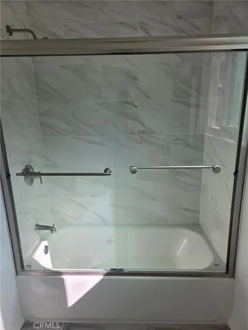 a bathroom with a granite countertop toilet and a shower