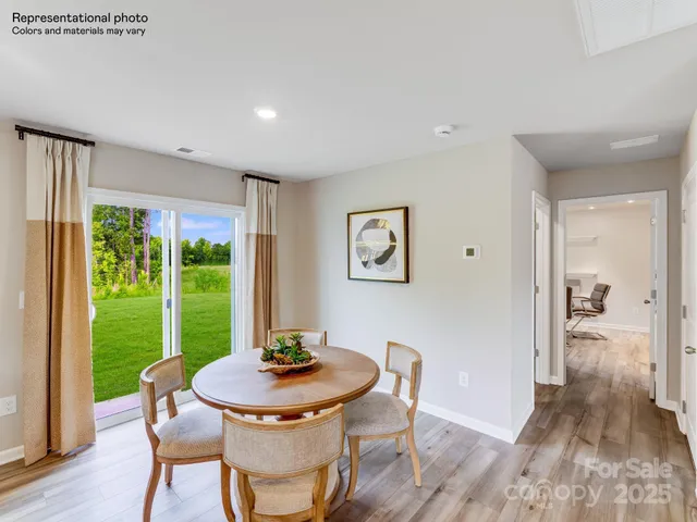 a living room with stainless steel appliances furniture a rug and a kitchen view