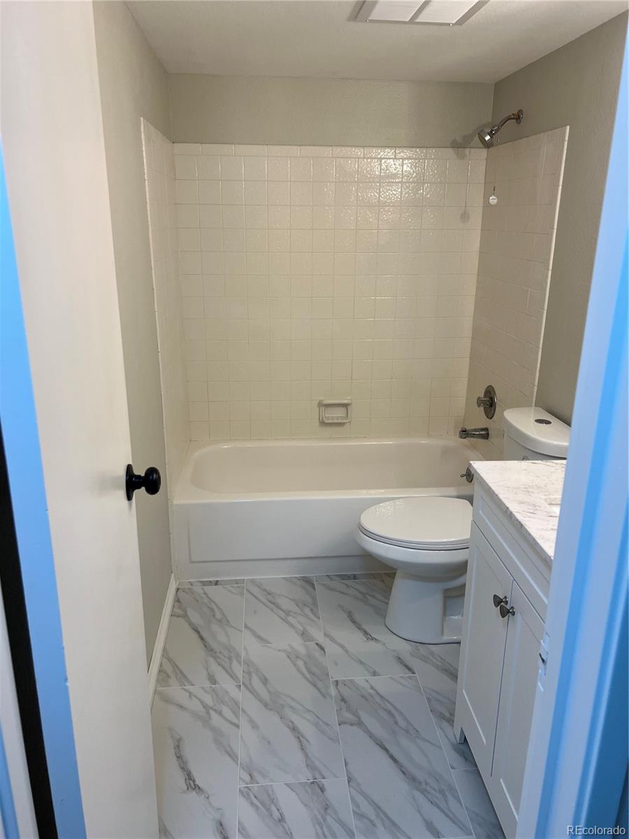 2880 South Locust Street, Unit 507S Denver, CO 80222 - Photo 35 of 48 a bathroom with a granite countertop bathtub shower sink vanity and toilet
