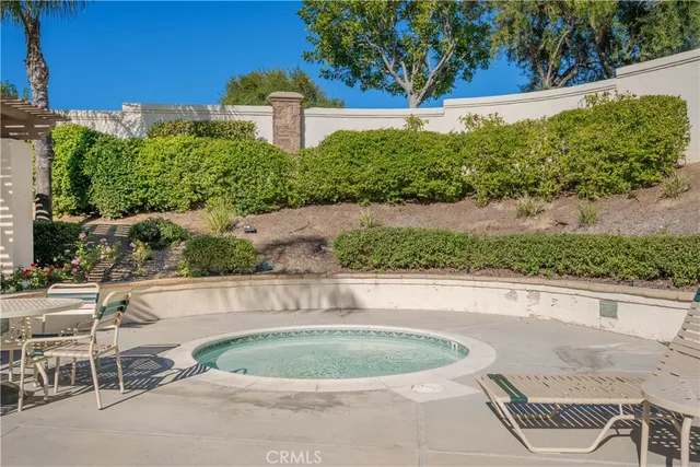 a patio with table and chairs and potted plants