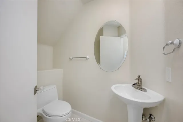a bathroom with a sink toilet and a mirror