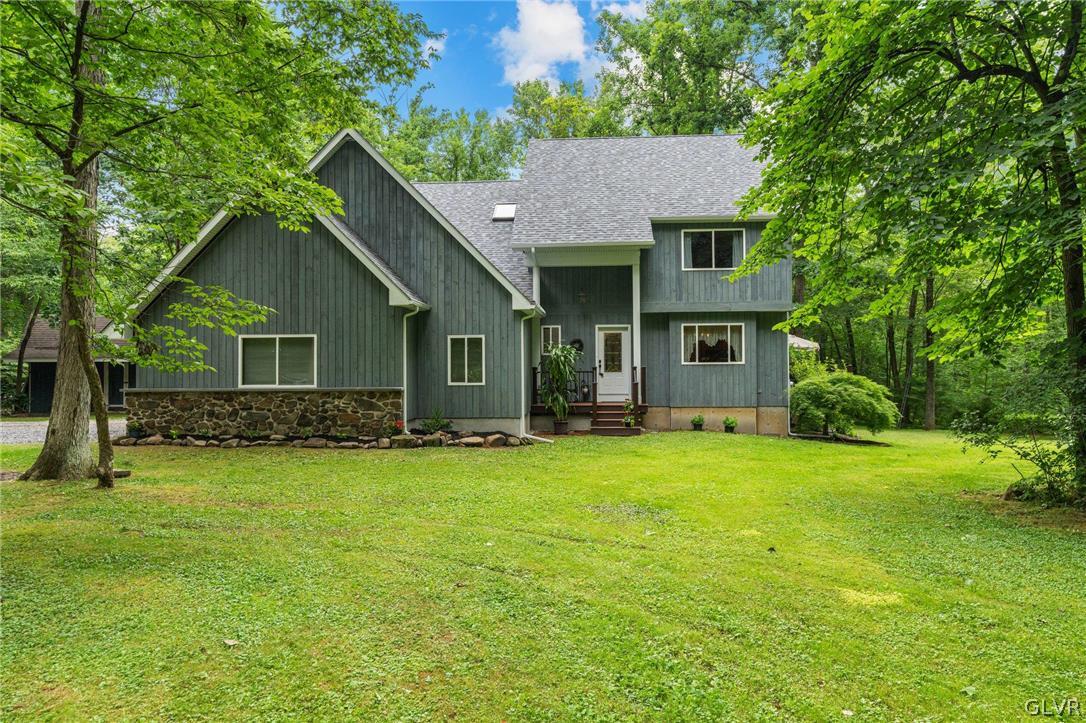 3220 Winding Road Kintnersville, PA 18930 - Photo 1 of 50 a front view of a house with a garden