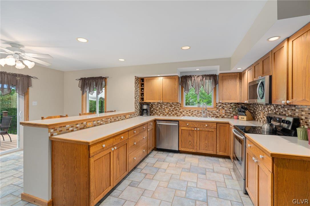 3220 Winding Road Kintnersville, PA 18930 - Photo 26 of 50 a kitchen with stainless steel appliances granite countertop a stove a sink and a refrigerator